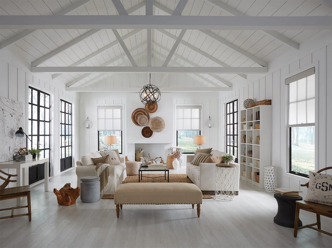 Spacious living room with large windows and motorized roller shades filtering warm afternoon light